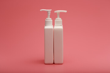 Two unbranded tubes with cream on pink background