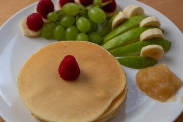Pancakes mit Obst und Nutella oder Sternen auf einem Teller angerichtet Bunt