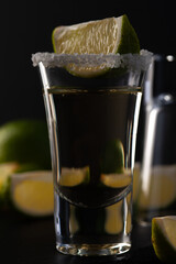 Gold Mexican Tequila shot with lime slice and salt.