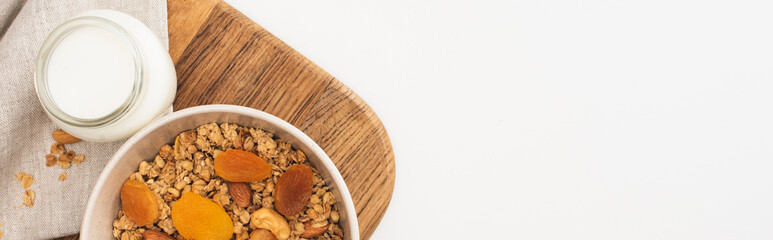 top view of delicious granola with nuts, yogurt and dried apricots isolated on white, banner