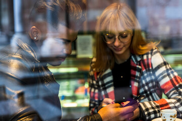 young multiethnic couple chatting on their mobile phones