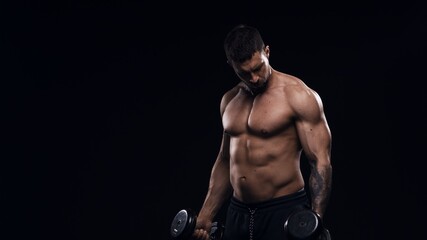 Fototapeta na wymiar Fit and sporty bodybuilder over black background. Sportsman in studio. Sport and fitness concepts.