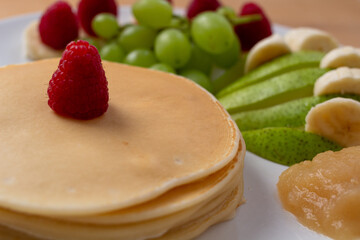 Pancakes mit Obst und Nutella oder Sternen auf einem Teller angerichtet Bunt