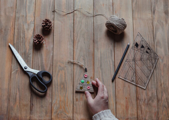 A woman holds a handmade Christmas tree toy in her hand. Concept of xmas diy. Top view