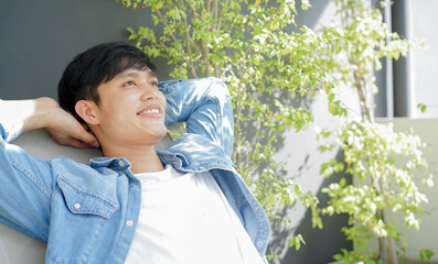 close up young asian laying on couch at garden outside home to relax with wellbeing feeling for mindfulness and lifestyle concept