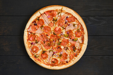 Pizza with pepperoni, ham, bell pepper, olives and red onion