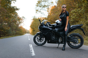 Fototapeta na wymiar Stylish female motorcyclist on the road