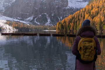 A woman looking at the lake with some mountains in the background.