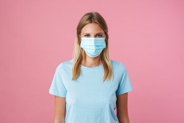 Blonde caucasian girl in face mask posing and looking at camera