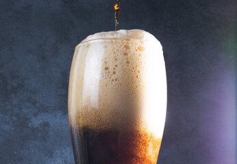 Beer Glass, much foam. Beer bubbles closeup. Overflow beer glass. Beer beverage. Glass of alcohol. Closeup Cold Beer.