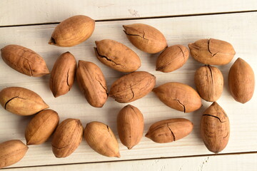 Obraz premium Not peeled pecans, close-up, on a wooden table.