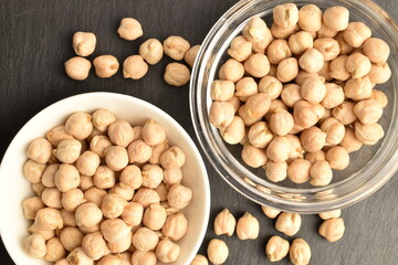 Uncooked hummus grains, close-up, on a slate board.