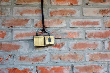 Old grungy brick wall with electric switch. Vintage wall with obsolete plaster