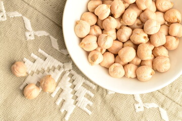 Uncooked hummus seeds, close-up, on a linen napkin.
