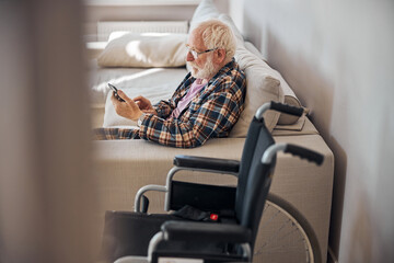 Senior man reading news on his gadget