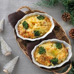 Homemade gratin with shrimp and cheese in baking dishes on Christmas decoration table. Flat lay, top view.
マカロニグラタン　クリスマス