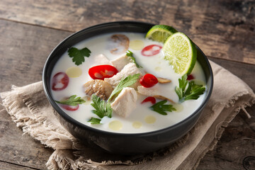 Traditional Thai food Tom Kha Gai in bowl on wooden table