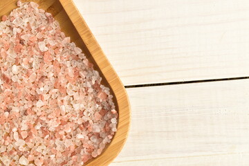 Himalayan salt, close-up, on a white wooden table.