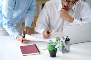 Diverse male mentor and intern talking pointing on paper