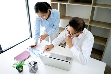 Fototapeta premium A businessman mentor and intern woman staff consultant holding graph paper together in a long line during teaching coach in business training