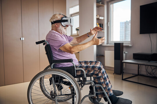 Senior Caucasian gamer immersing himself in virtual reality