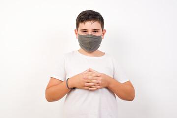 Business Concept - Portrait of Caucasian young boy wearing medical mask standing against white background holding hands with confident face.