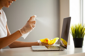 Woman disinfect laptop and smartphone by wet wipes and antiseptic