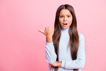 Portrait of attractive outraged mad girl demonstrating copy empty place space isolated over pink pastel color background