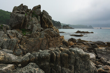 Fototapeta na wymiar Cloudy summer day on the sea with a rocky shore coastline of the Bay.