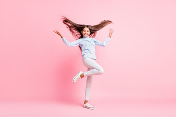 Full length body size view of charming cheerful girl throwing hair having fun isolated over pink pastel color background