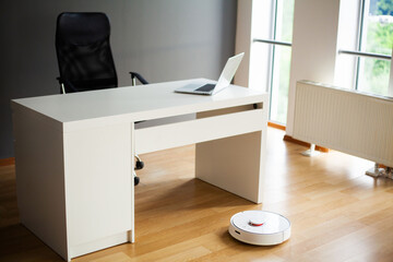 Robot vacuum cleaner performs automatic cleaning of the apartment at a certain time. Smart home.