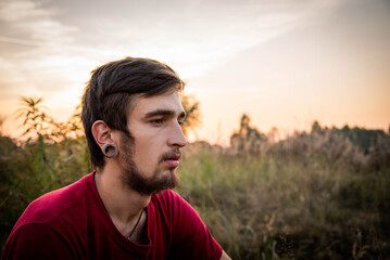 Close up of informal teen boy smoking cigarette / weed at outdoor. portrait of a boy smoking.