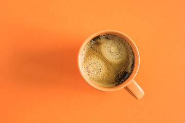 Orange cup of coffee on oranпe background