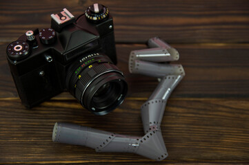 camera and photo film on a wooden surface
