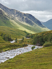 Glen Etive, a remote valley near Glencoe in the mountains of the Scottish Highlands, where the River Etive flows between banks lined with heather and bracken.