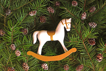 retro Christmas background with a small rocking horse on fir branches
