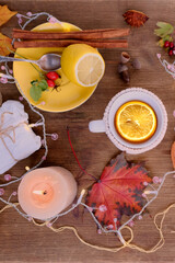 beverage, hot drink in a mug, leaves, foliage, garland, candles, top view of wooden table, good weather concept, outdoor tea party, cozy autumn mood