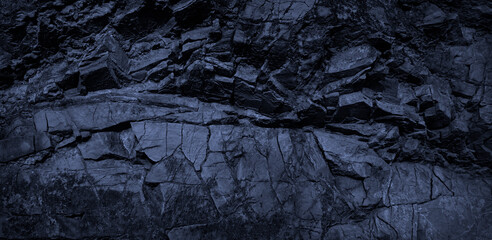 Dark blue rock background. Monochrome toned rocky stone texture. Collapsed weathered mountain surface. Close-up. Deep blue volumetric rock background. 3d effect.