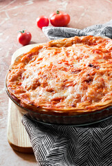 Homemade baked lasagna in round glass baking dish 