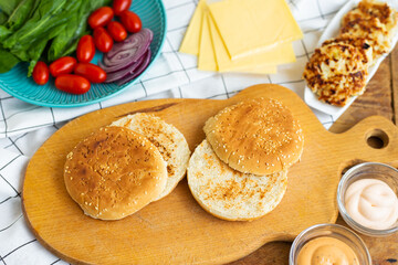 Preparation of all the ingredients for the preparation of a delicious bun burger, cutlet, cheese, salad, tomato, sauces.