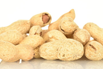 Unpeeled organic peanuts, close-up, on a white background.
