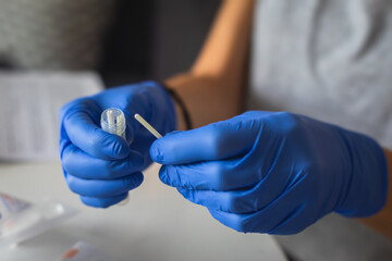 Process of coronavirus testing examination at home, COVID-19 swab collection kit, test tube for taking OP NP patient specimen sample, testing carried out, patient receiving a corona test