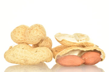 Unpeeled organic peanuts, close-up, on a white background.