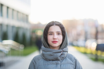mixed race girl woman portrait outdoor. teen student looks at camera against city college background