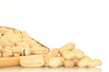 Unpeeled organic peanuts, close-up, on a white background.