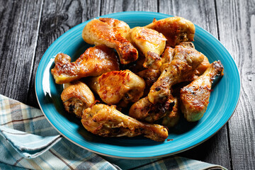 Crispy baked chicken drumsticks on a blue plate