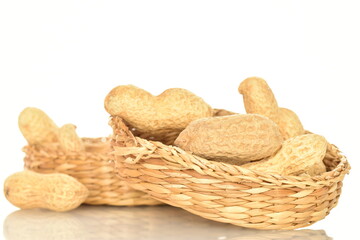 Unpeeled organic peanuts, close-up, on a white background.