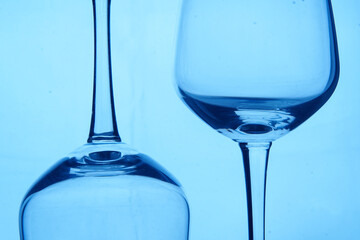 Perspective of two drinking glasses on blue background