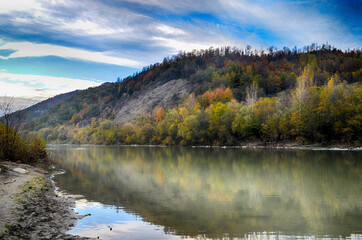 Beautiful landscape with high mountains with illuminated peaks, stones in mountain lake, reflection, blue sky and sunrise. HDR
