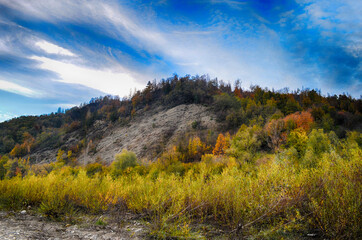 Beautiful landscape with high mountains with illuminated peaks, stones in mountain lake, reflection, blue sky and sunrise. HDR